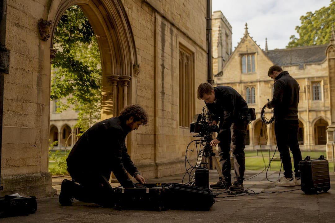 Film crew setting up lighting at historic filming location